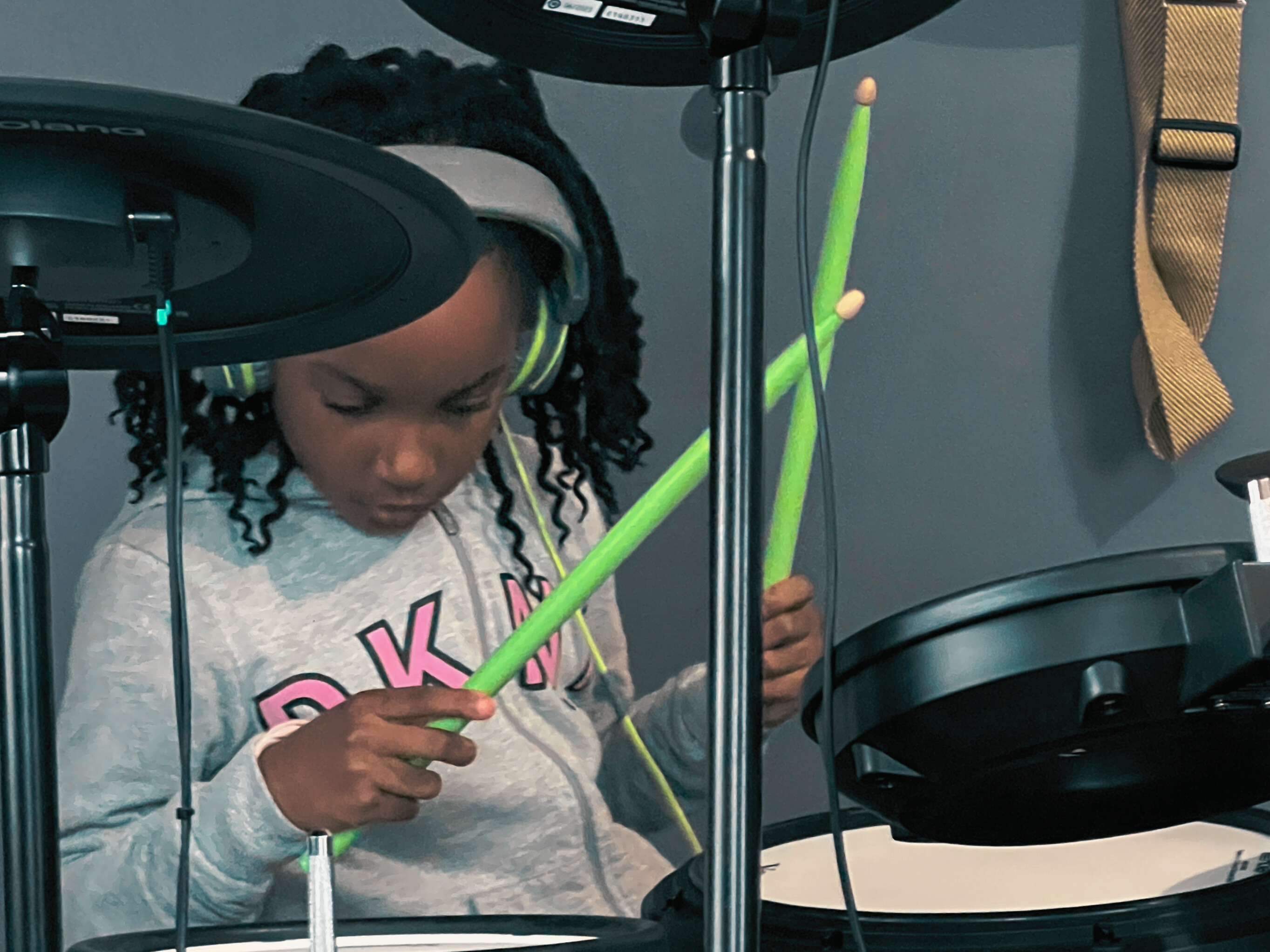 Child deeply focused while playing drums